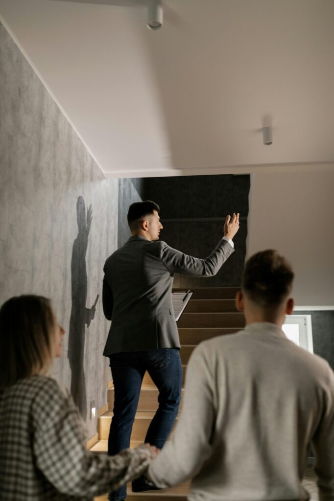 pexels photo 7641896 7641896 A real estate agent leads a couple on a house tour, highlighting interior features in a modern home.